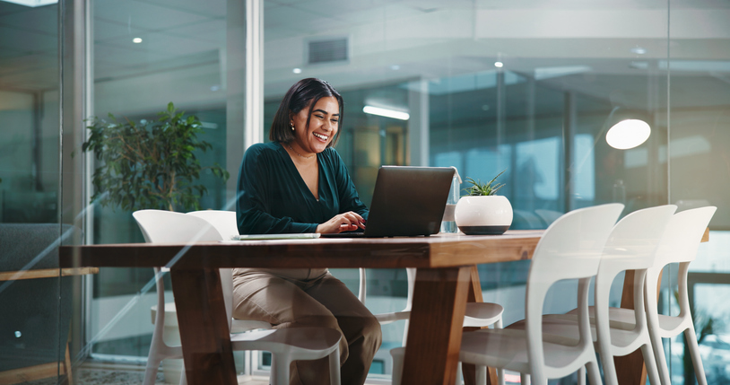 Woman reviewing SEO analytics and developing an SEO strategy on a computer in a modern office.