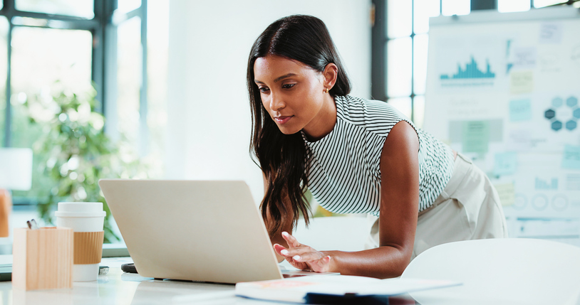 Woman reviewing a website SEO audit and analyzing website performance on a laptop.