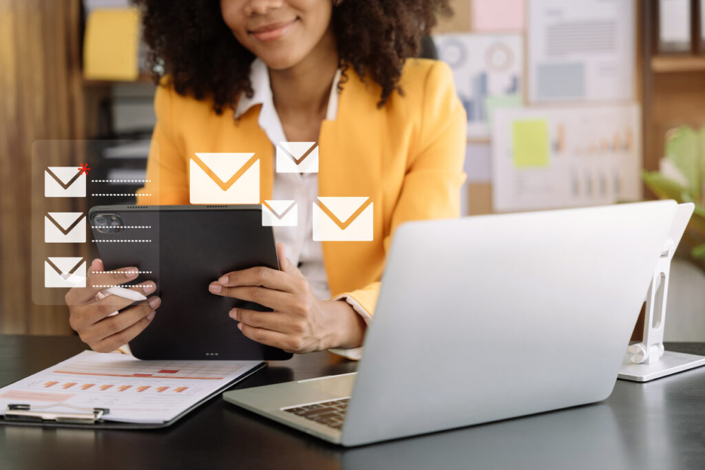 Business owner managing email marketing campaigns on a laptop, tablet, and smartphone.